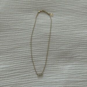 Gold Kendra Scott necklace with sparkly white center stone